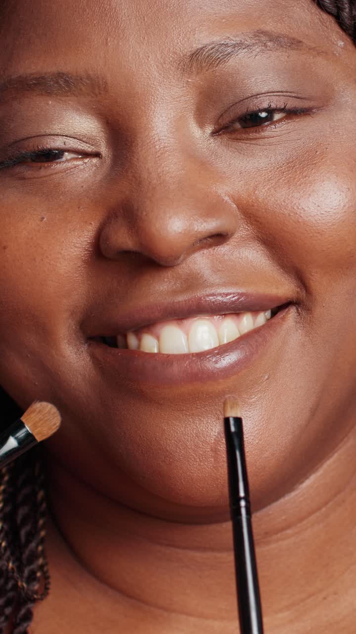 Vertical video: Confident woman having make up done by specialists