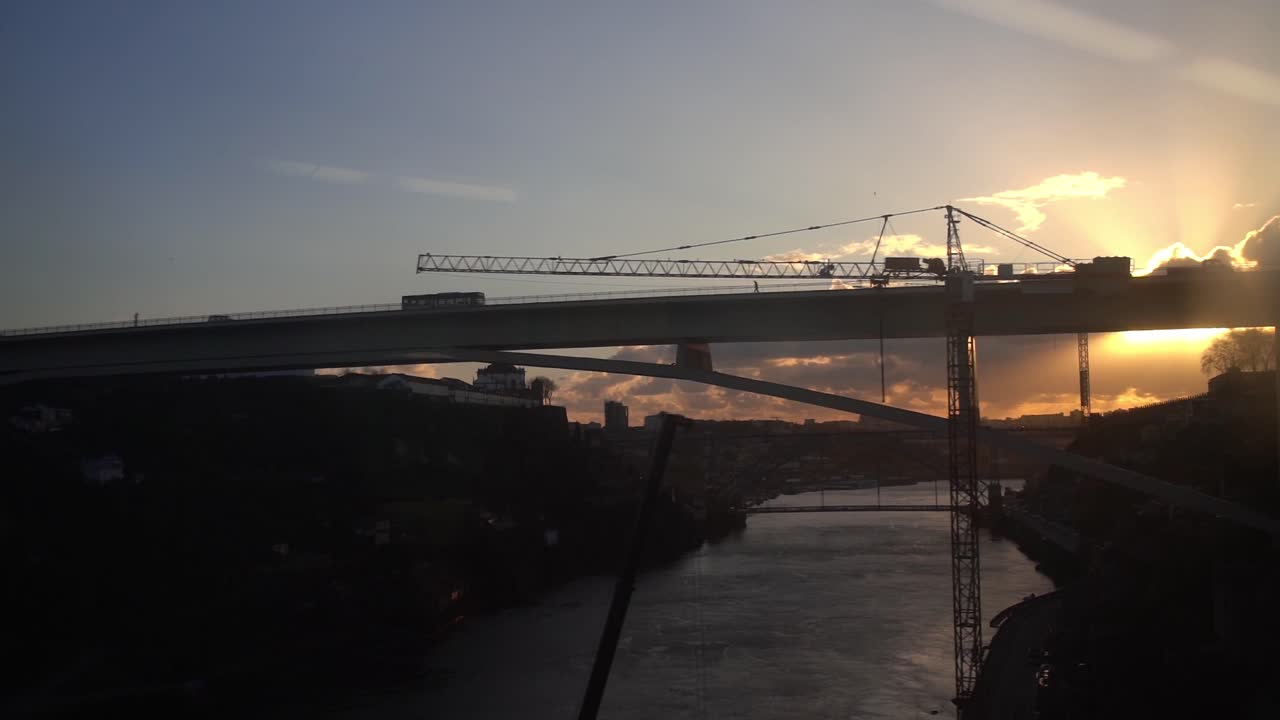 Golden Sunset View From Car Window Across Ave River In Portugal With Crane In View. Slow Motion