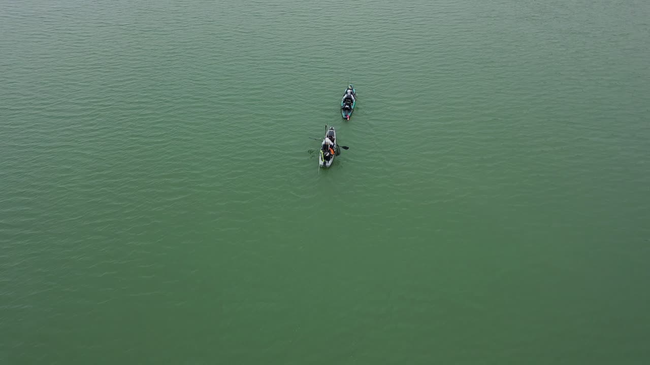안개가 자욱하고 추운 날 레이니어 호수에서 두 명의 카약을 타는 사람의 역방향 공중 공개