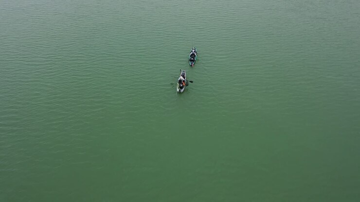 Reverse aerial reveal of two kayakers on Lake Lanier on a fogged and cold day