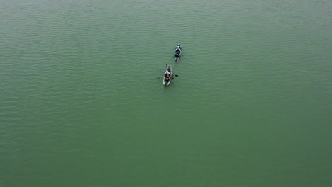 revelación aérea inversa de dos kayakistas en el lago lanier en un día nublado y frío