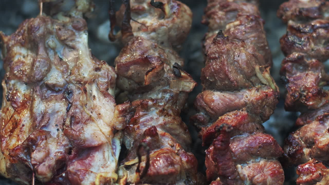 Carne alla griglia su spiedini al picnic. Primo piano di shish kebab che griglia su una griglia a carbone.
