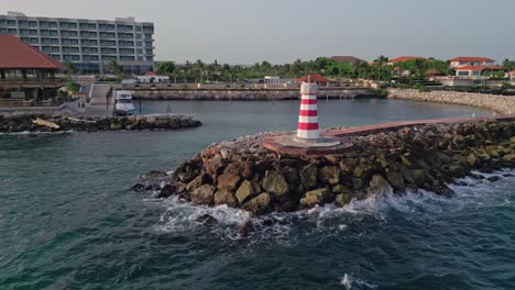 red and white lighthouse in front of hilton hotel in the dominican republic