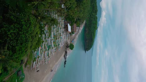 vertical-drone-shot-of-boats-on-beach-coast-of-bali,-tourist-fishing-trips