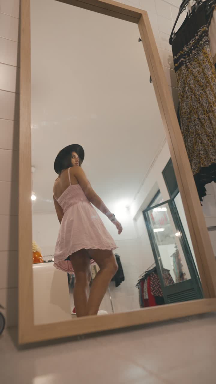 Una donna in abito si guarda allo specchio