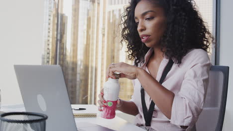 Vielbeschäftigte-Geschäftsfrau-Mit-Laptop-Sitzt-Am-Schreibtisch-Und-Trinkt-Proteinshake-Zum-Arbeitsessen