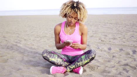 mujer joven de moda escuchando música en la playa