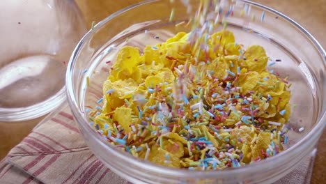 flocos de maíz amarillos crujientes en el cuenco para la mañana un delicioso desayuno con leche. cámara lenta con toma de seguimiento de rotación.