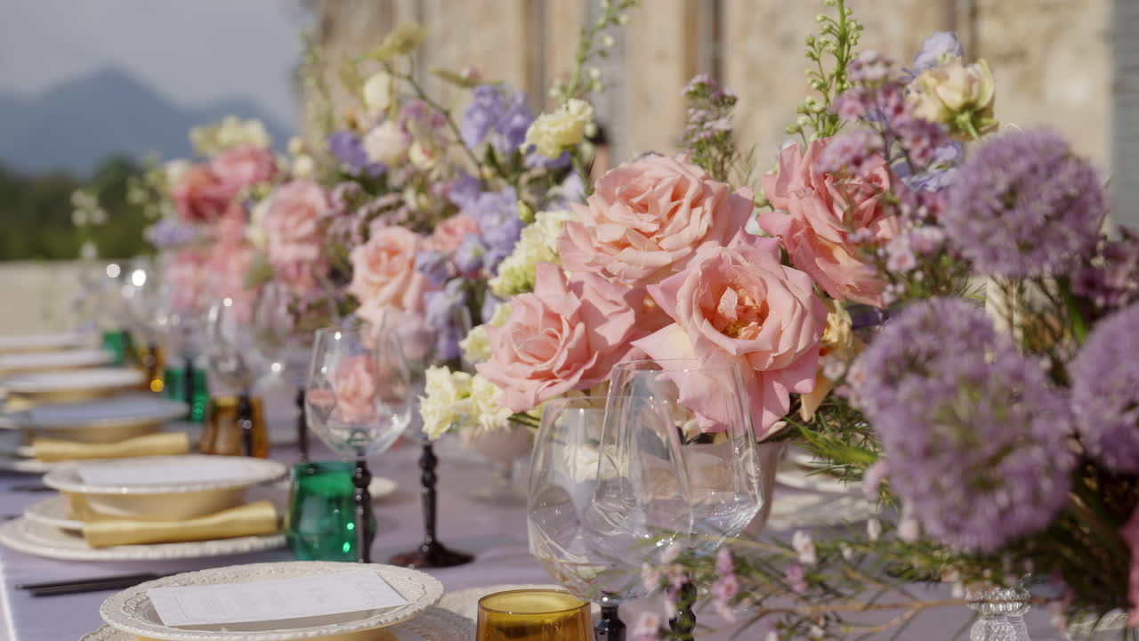 Elegante allestimento tavola esterno con composizioni floreali
