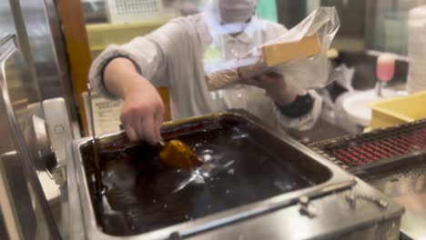 dipping mitarashi dango japanese rice cakes dessert into sweet soy sauce glaze