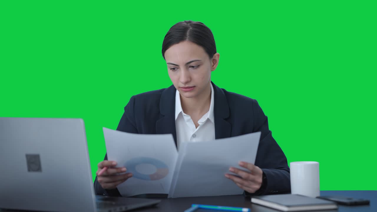 Seria donna d'affari indiana che controlla i rapporti. Schermo verde