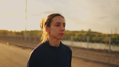 dedicated female athlete is running outdoors in morning portrait of sportswoman during jog