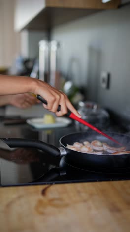 mujer cocinando camarón en una cocina
