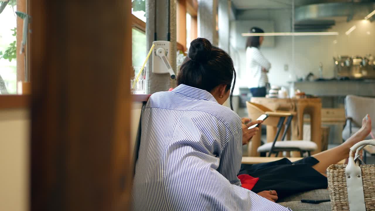 카페에서 함께 앉아 사진을 보고 있는 친구들