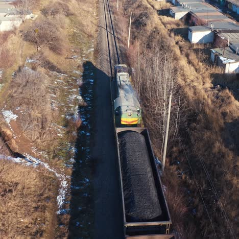 cargo train on a railroad in sunny winter day. top view on a freight train on the background of many garages from both sides. aerial view.