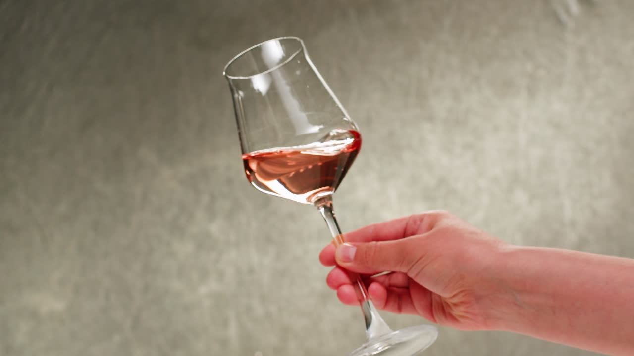 Rosé, orange eller hvidvinsflaske og glas mod en solnedgang i en fredfyldt vingård, hvor der hældes økologisk naturvin op. Skål, hænder med vinglas, der drikker alkohol