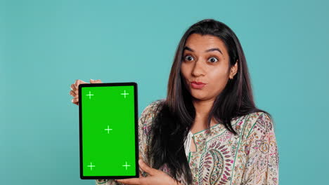 retrato de una mujer haciendo marketing de influencia usando una tableta de pantalla verde