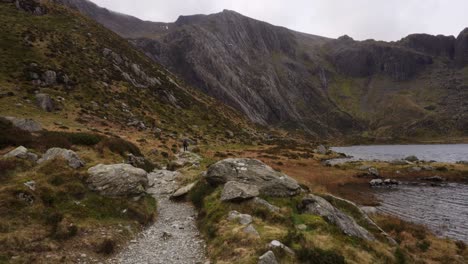 Walking-along-Llyn-Idwal,-a-beautiful-lake-in-Snowdonia-National-Park,-North-Wales-on-a-windy-day