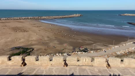 Mucha-Gente-Del-Norte-De-África-Jugando-Alegremente-En-La-Amplia-Playa-De-Rabat-En-Un-Día-Soleado