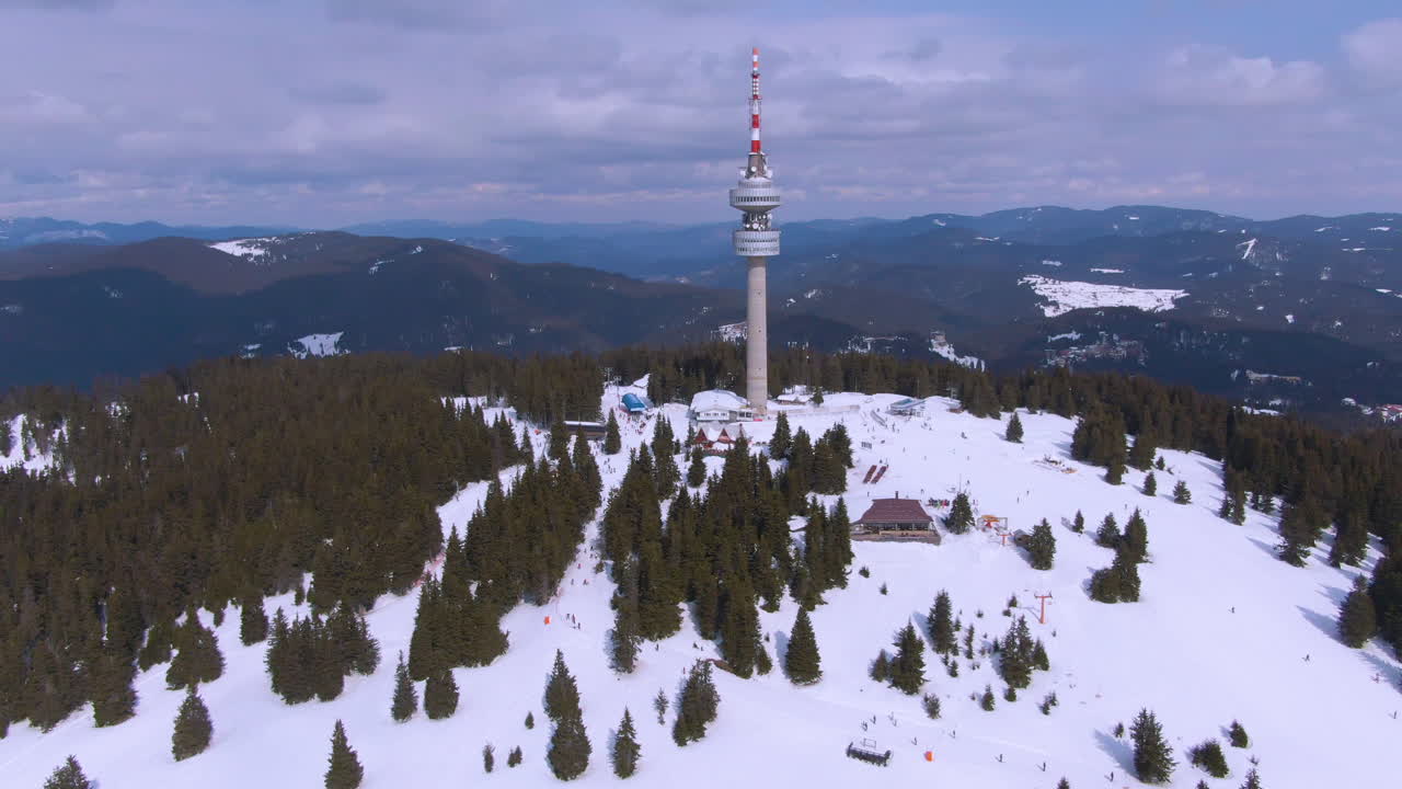 Winter ascending drone shot revealing ski lift and TV tower