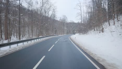 first person view of a car driving through a beautiful winter landscape with lots of snow and ice