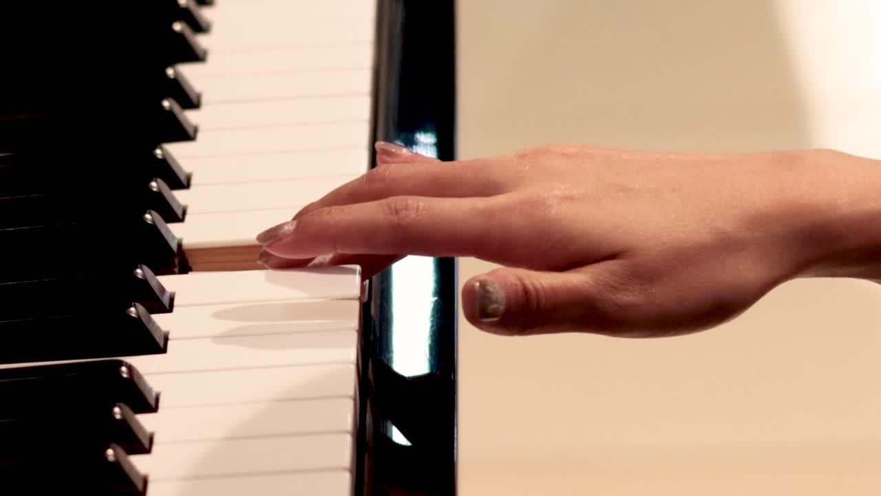 Detailed view of fingers gracefully playing piano keys, showcasing hand positioning and movement.