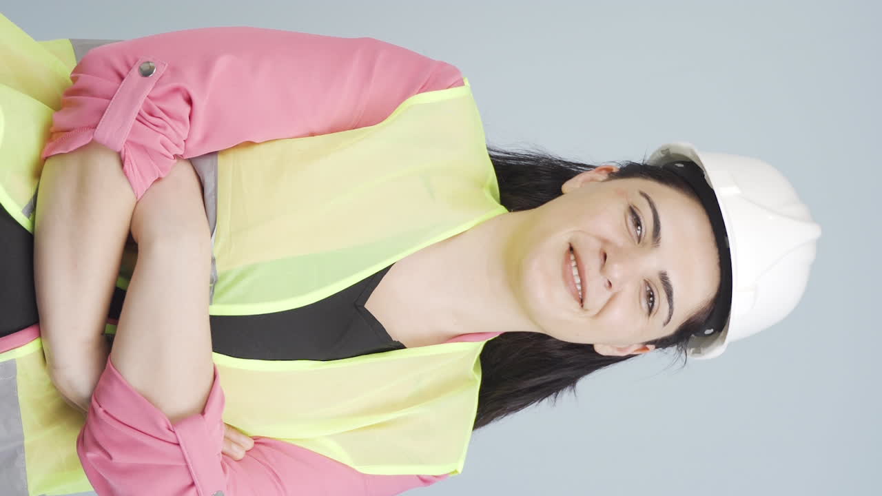 vídeo vertical de la ingeniera cruza los brazos y se ríe de la cámara.