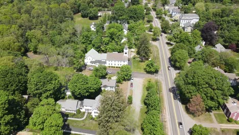 aerial pull back rising shot over typical rural american countryside town in massachusetts with a church as the center focus