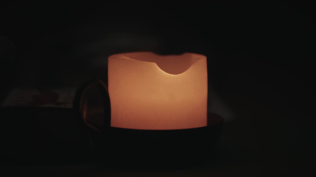 Primo piano di una candela accesa al buio per creare un'atmosfera rilassante