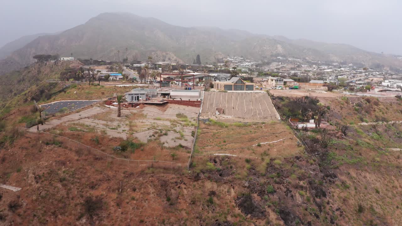 Aerial rising shot revealing the burned Sunset Mesa neighborhood in Malibu after the Palisades wildfire in Southern California. 4K
