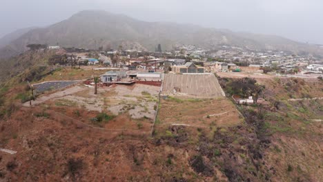 aerial rising shot revealing the burned sunset mesa neighborhood in malibu after the palisades wildfire in southern california. 4k