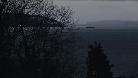 distant ferry on water with land in background in winter