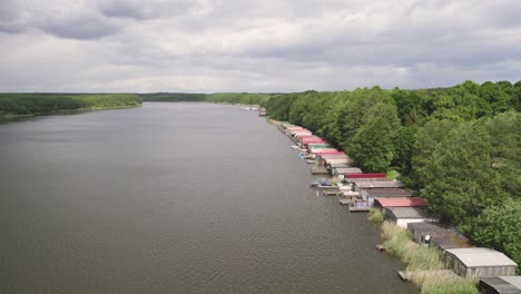 Drone-shot-of-huts-by-the-lakeside-forest-of-Lake-Mirow