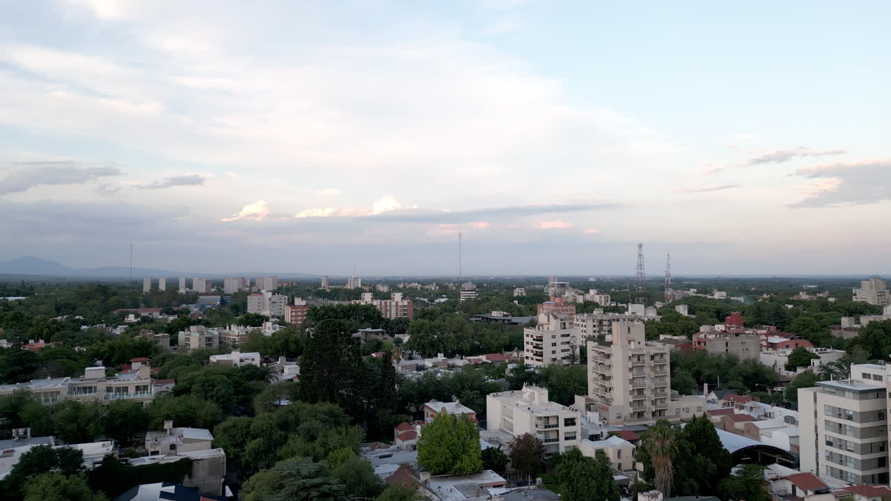 Vista aerea di una città con edifici e alberi verdi sotto un cielo nuvoloso