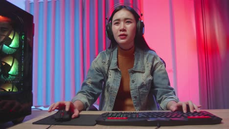 asian girl gamer lose while playing video game on computer