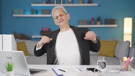 home office worker man yawns and relaxes at the camera.