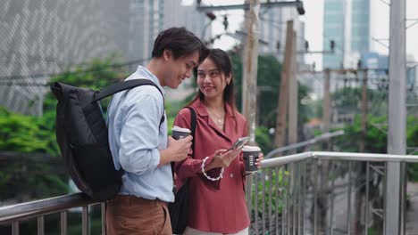 young couple using smartphone on city overpass