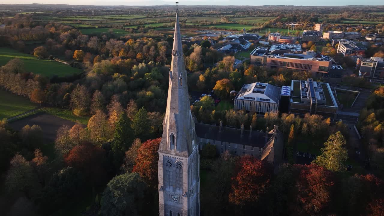 Beeindruckende Drohnen-Spirale über den Turm der alten Kirche in der Universität Maynooth, Enthüllung der Sonne. Irland