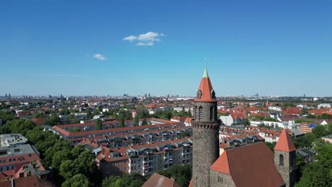 Majestic-aerial-top-view-flight-Bell-tower-Lukas-church-city-Berlin-steglitz,-Germany-Summer-day-2023