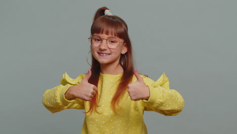happy preteen child girl kid looking approvingly at camera showing thumbs up like positive sign