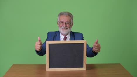 hombre de negocios barbudo y guapo contra un fondo verde.