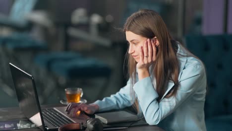 chica guapa buscando cuidadosamente en internet en una laptop