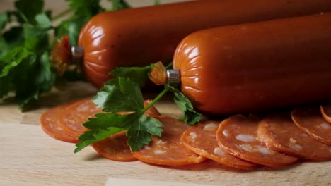 sliced pepperoni and whole sausages on wooden board