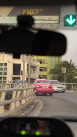 pink taxi in a city street