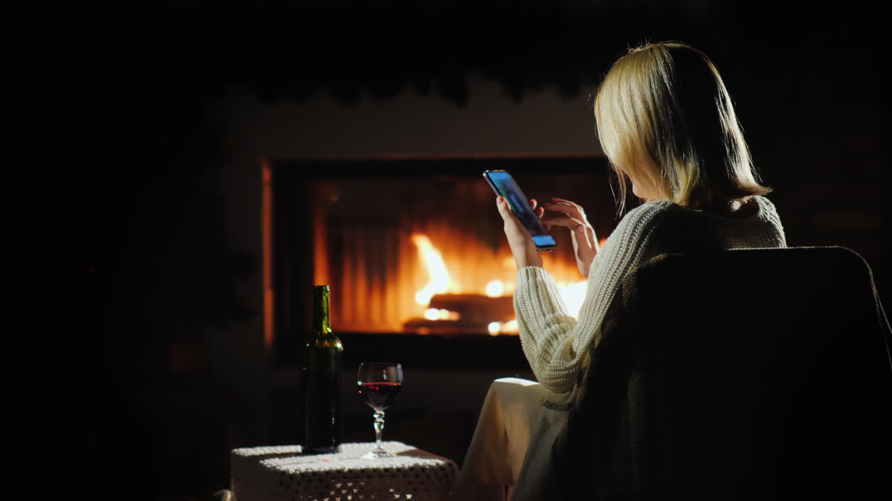 mujer comprando en línea en un ambiente agradable junto a la chimenea