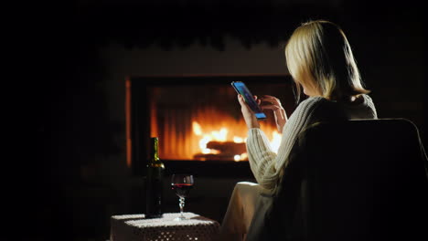 mujer comprando en línea en un ambiente agradable junto a la chimenea