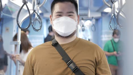 asian man wearing face mask protect covid-19 in subway train