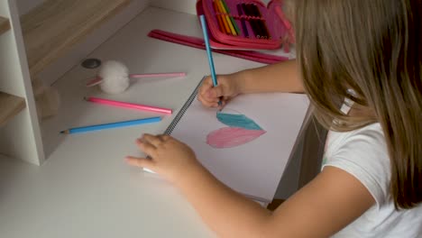 Overhead-of-a-little-girl-at-her-table-drawing