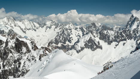Zeitraffer,-Sonnige,-Schneebedeckte-Alpengipfel-Und-Bergsteiger,-Die-Bergauf-Gehen