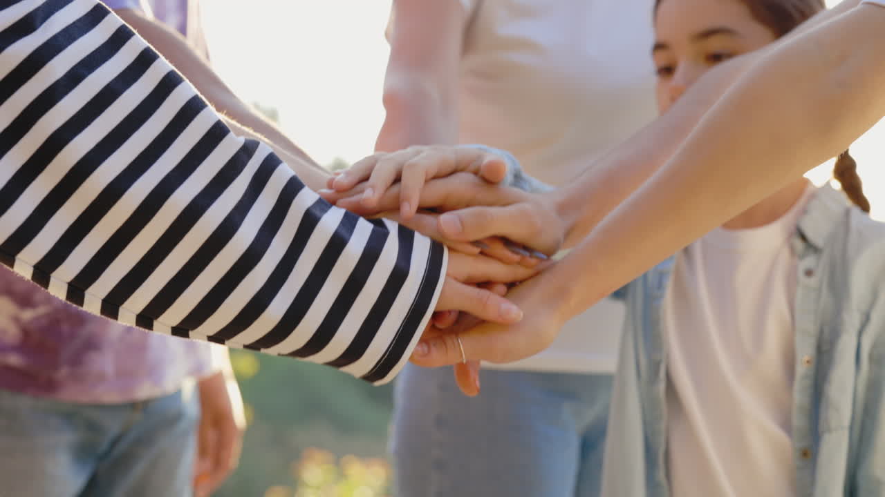 Group of People Stacking Hands in a Display of Teamwork